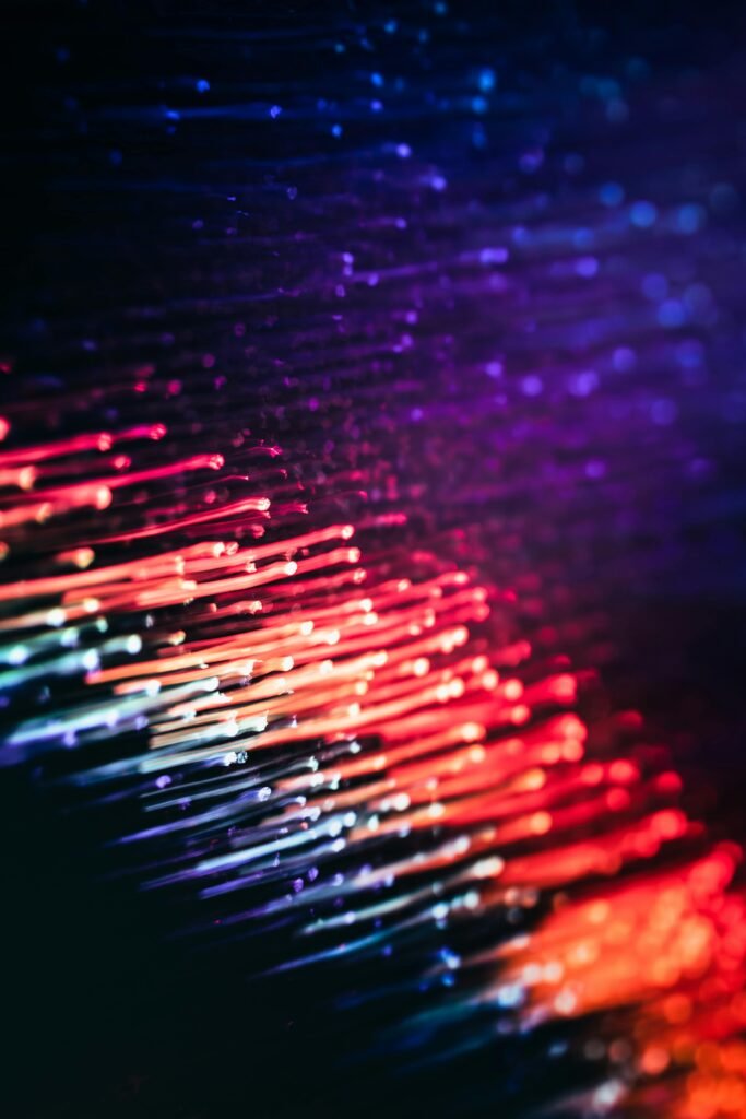 Colorful abstract light streaks creating a dynamic motion effect in a vertical composition.